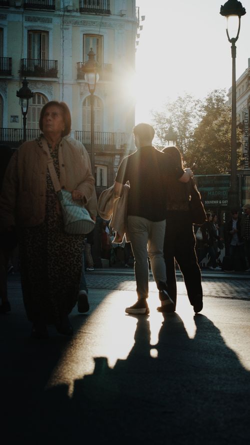Free Silhouetted people walking on a city street at sunset, creating a dramatic urban scene. Stock Photo