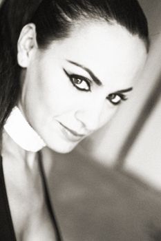 Artistic black and white portrait with dramatic eyeliner and high contrast lighting.