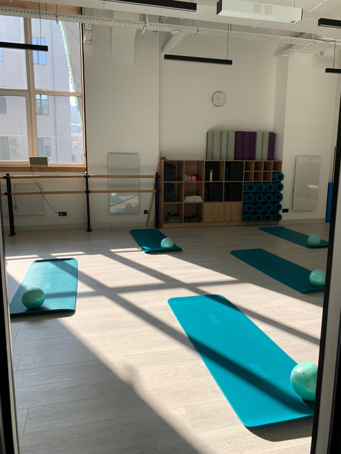 Heller Kursraum mit Matten und Pilatesbällen