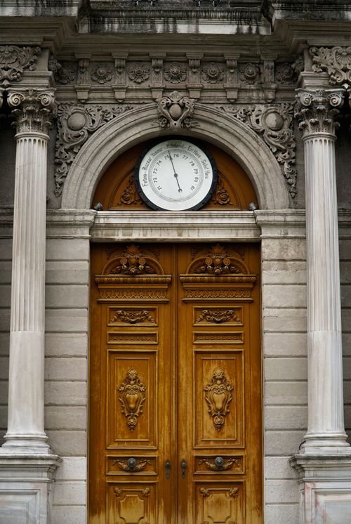 Free Intricately designed wooden door with barometer, flanked by ornate columns on a historic building facade. Stock Photo