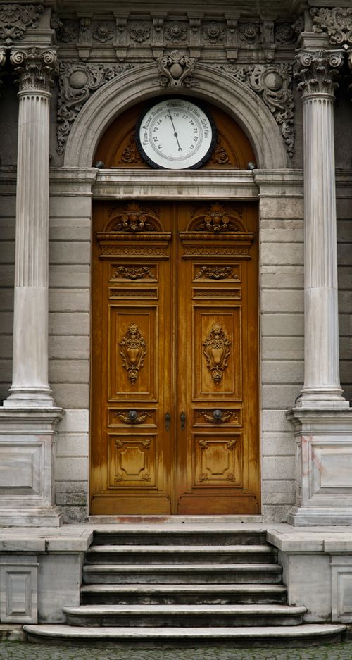 Free Sophisticated wooden door entrance with classical columns and ornate details. Stock Photo