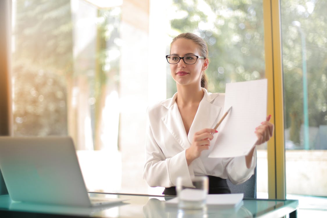 Free Intelligent businesswoman explaining documents in office Stock Photo