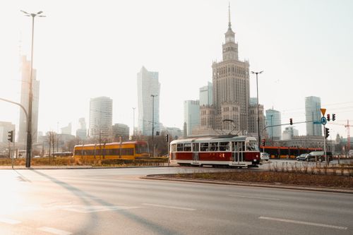 Free Historic tram passing through Warsaw's urban landscape with famous skyscrapers and the Palace of Culture and Science. Stock Photo