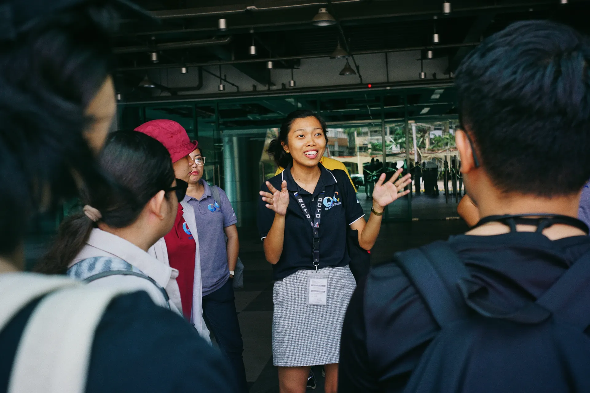 Tour guide leading a group tour, engaging visitors with gestures in an outdoor urban setting. Tour guide leading a group tour, engaging visitors with gestures in an outdoor urban setting.
