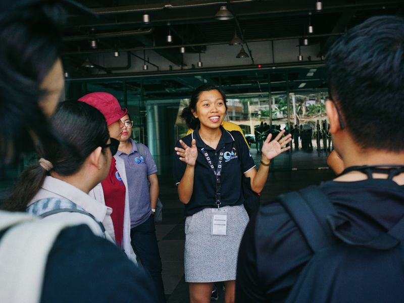Tour guide leading a group tour, engaging visitors with gestures in an outdoor urban setting - historic site operators