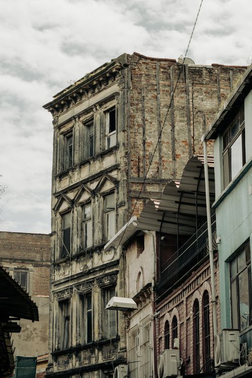 Free Aged buildings with intricate details and weathered facades nestled in an urban setting, showcasing historic architecture. Stock Photo