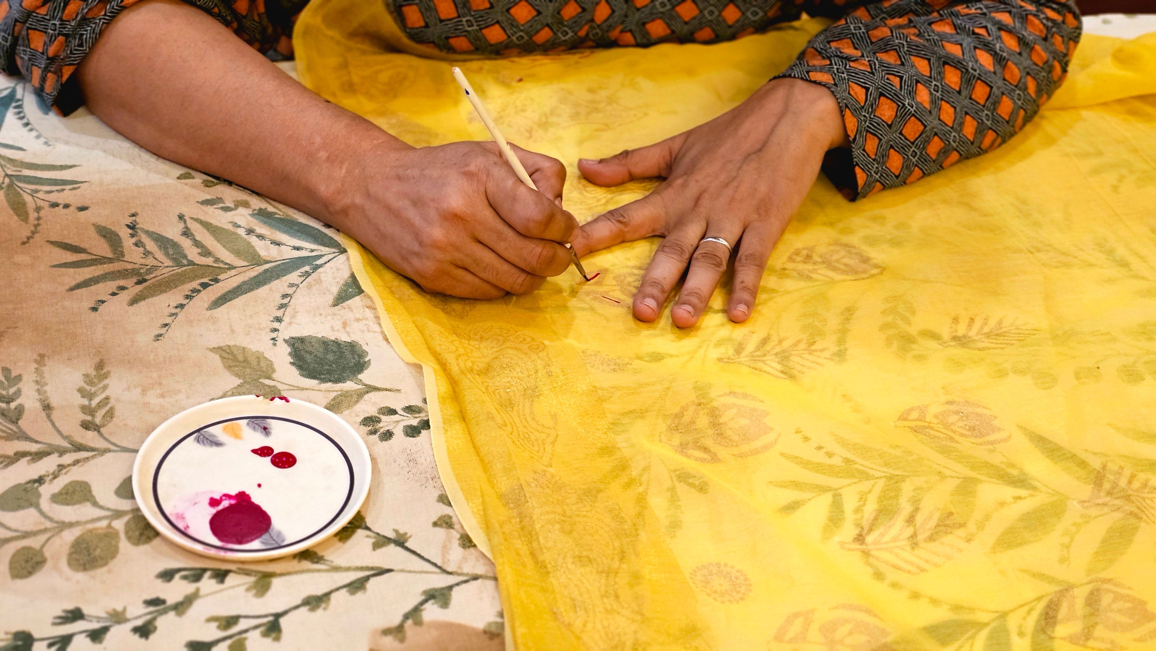 Artesão a pintar azulejo à mão com técnica tradicional