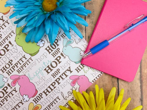 粉色精裝筆記本和藍色圓珠筆