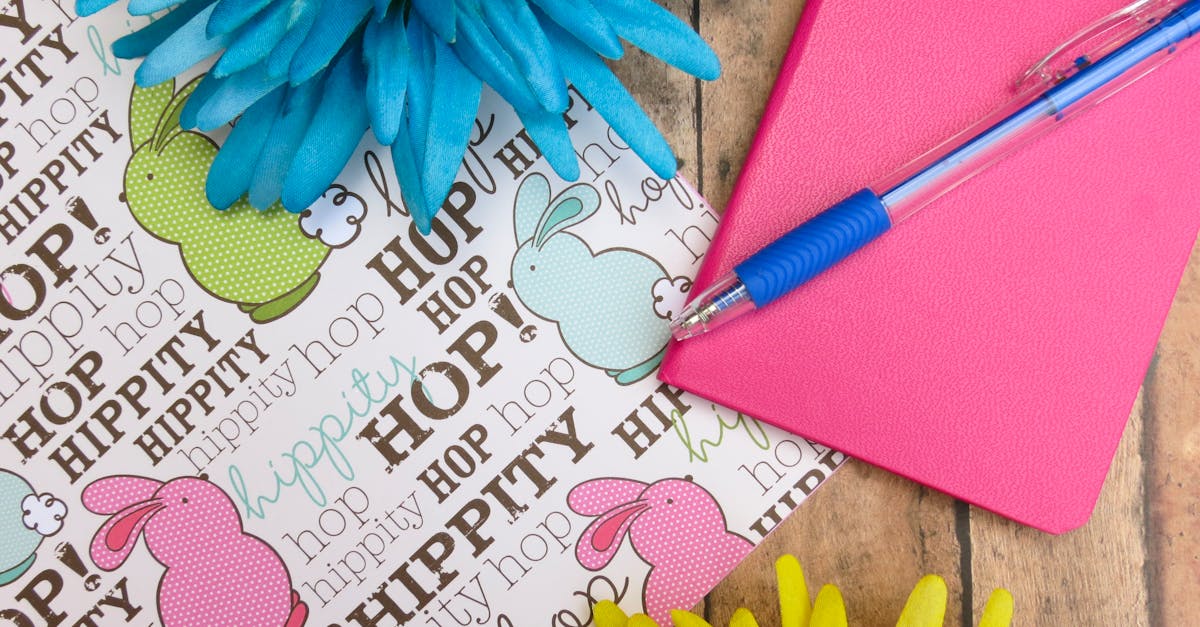 Pink Hardbound Notebook and Blue Ballpoint Pen