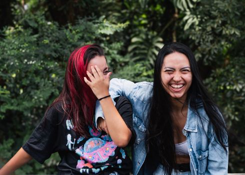 Two young women share a joyful moment outdoors, showcasing friendship and happiness.