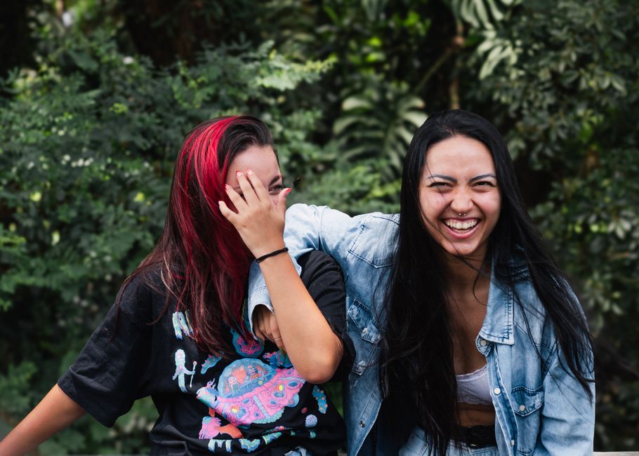 Como Criar um Encontro Virtual Inesquecível com Amigas 2 Two young women share a joyful moment outdoors, showcasing friendship and happiness.