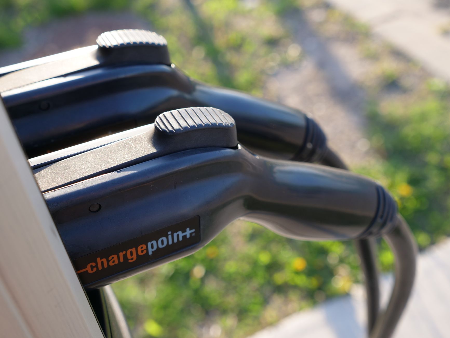 Detailed view of ChargePoint electric vehicle charging plugs at a station outdoors.