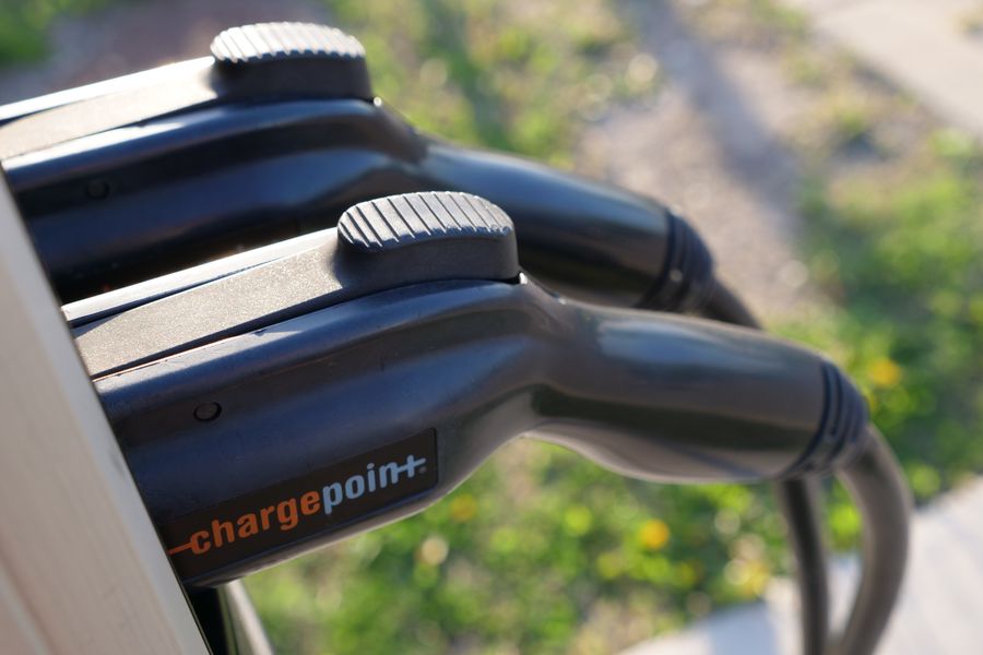 Detailed view of ChargePoint electric vehicle charging plugs at a station outdoors.