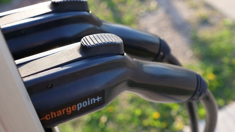 J1772 electric vehicle charging handle connected to an extension cord adapter