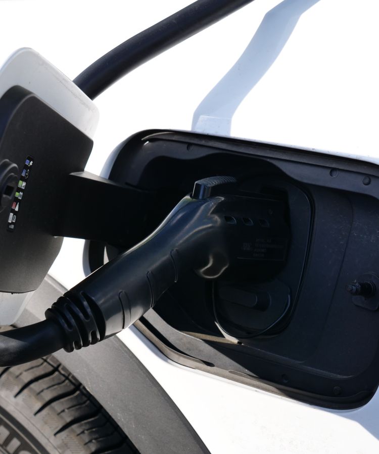 Close-up view of an electric vehicle charging with a focus on the connector and charging port.