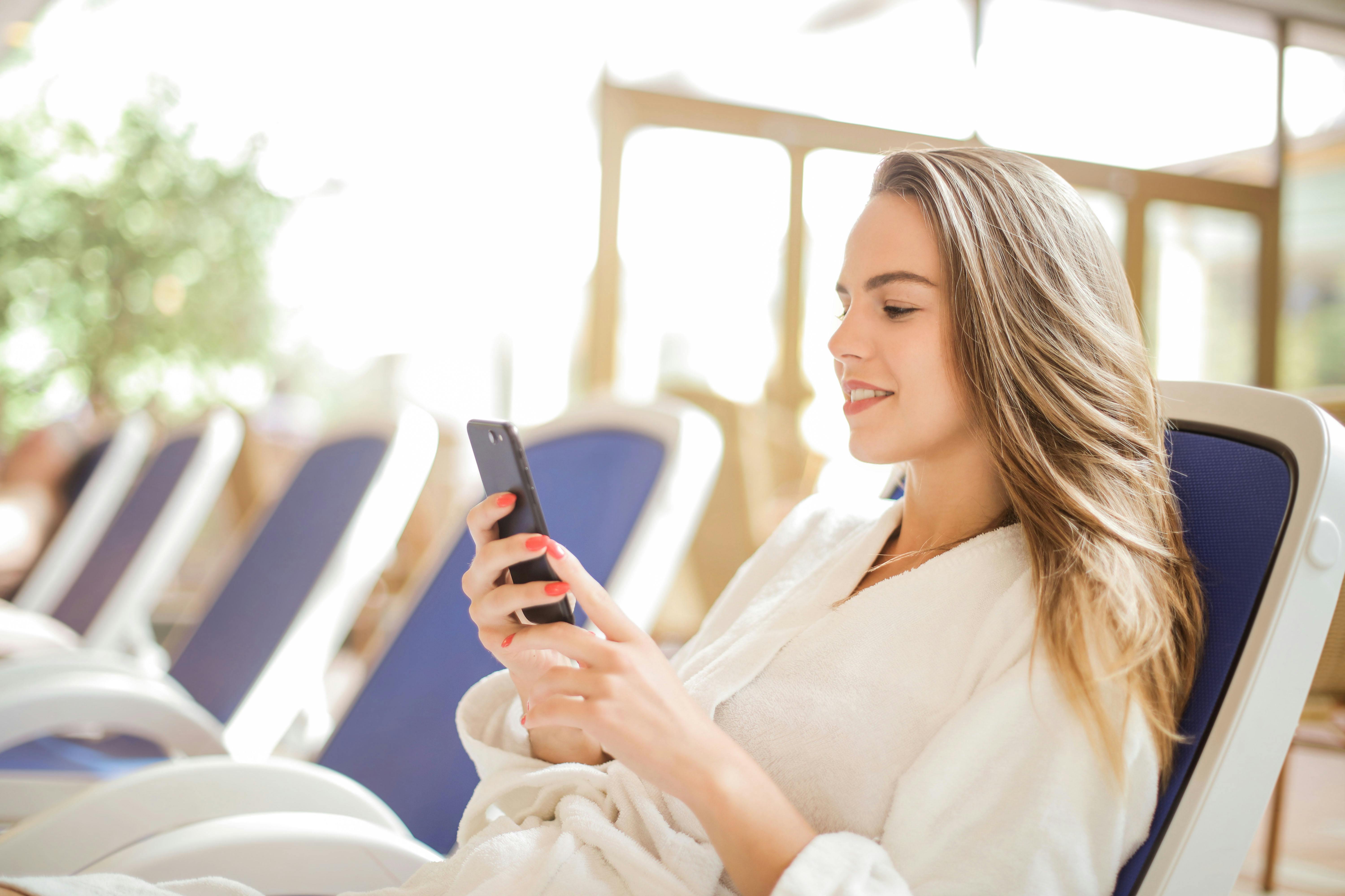一位穿着浴衣的年轻女子正舒适地使用智能手机，享受休闲时光