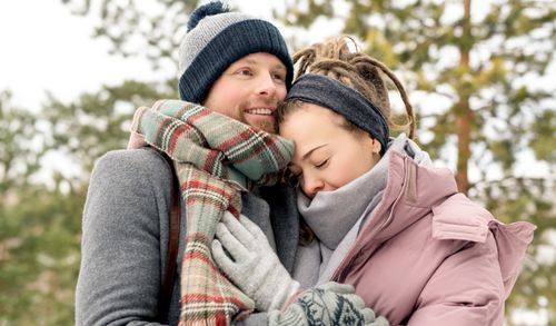 Free A loving couple embraces warmly in a winter setting, wrapped in cozy scarves. Stock Photo