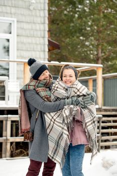Couple enjoying a warm embrace outdoors in a snowy winter setting. Perfect scene of love and togetherness.