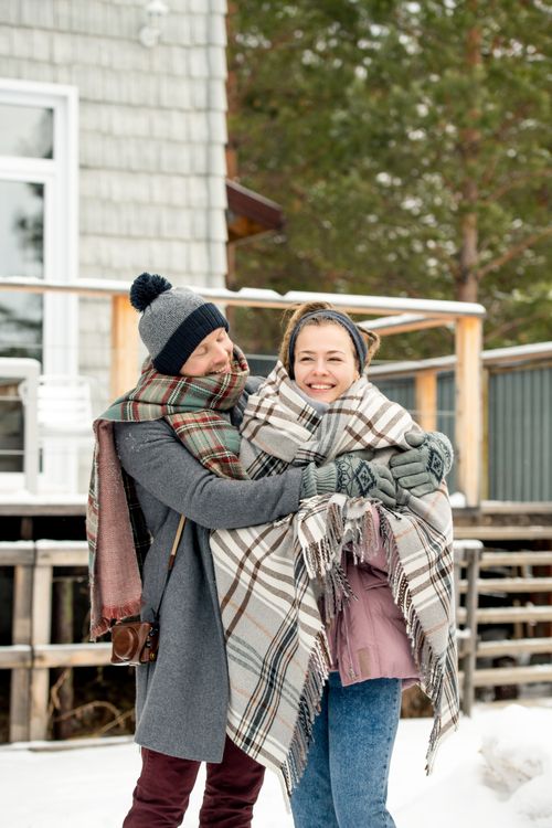 Free Couple enjoying a warm embrace outdoors in a snowy winter setting. Perfect scene of love and togetherness. Stock Photo