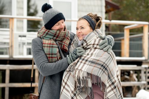 Free A couple warmly embracing outdoors, wrapped in winter attire, conveying love and togetherness. Stock Photo