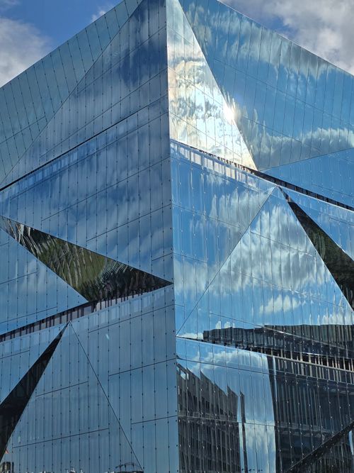 Free Stunning reflection of sky and clouds on a modern glass building facade. Stock Photo