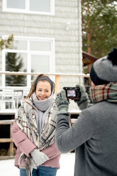 一名女子在屋前拍摄冬季肖像时，被另一个人捕捉到了她的姿态
