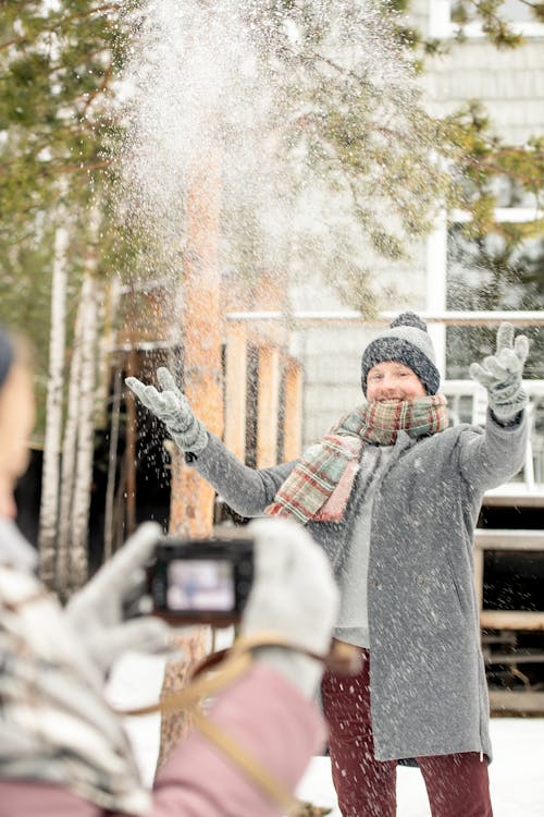 Man In Gray Coat Playing With Snow