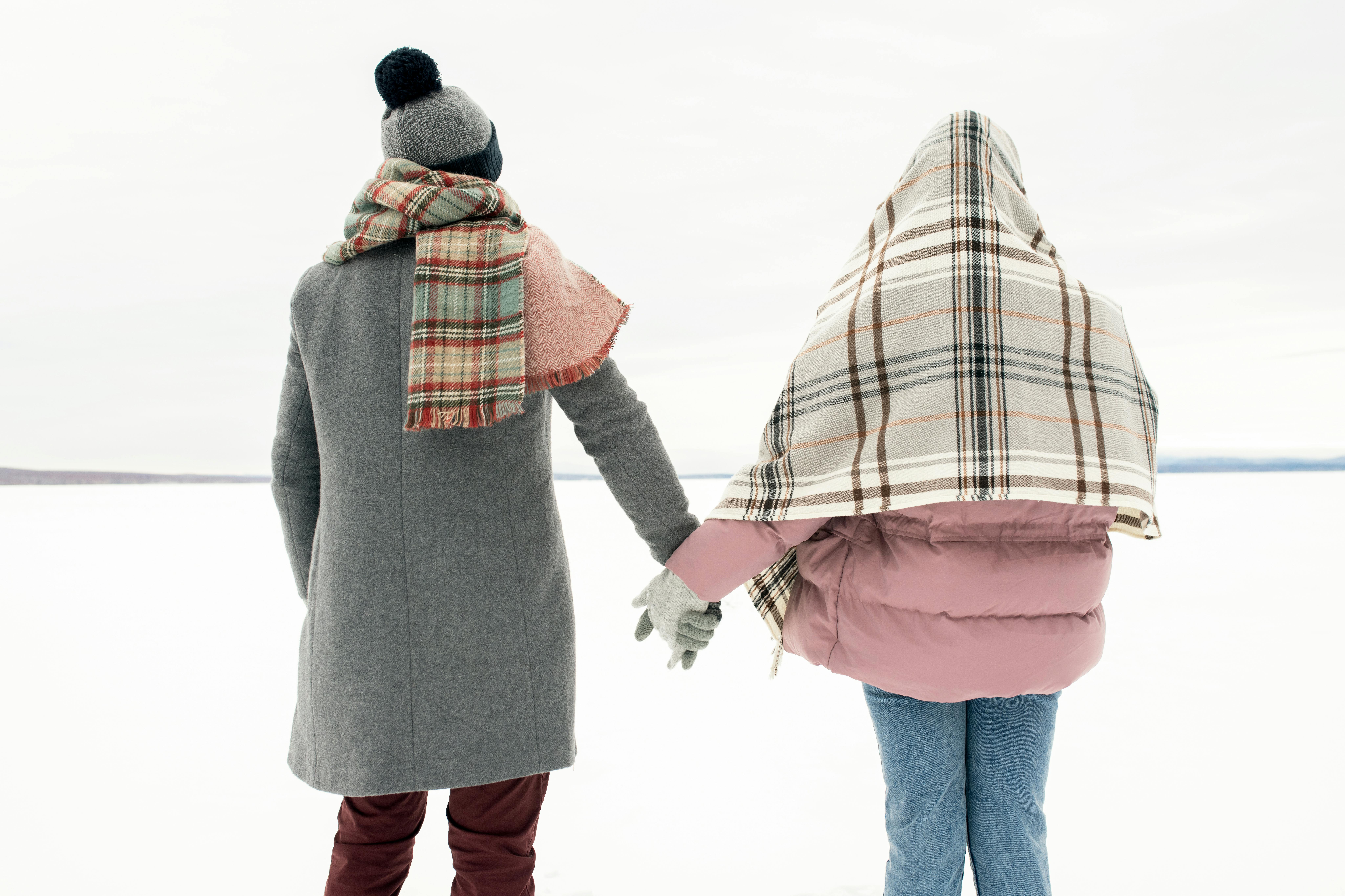 冬日雪景中，一对夫妇手牵着手，穿着温暖的衣服