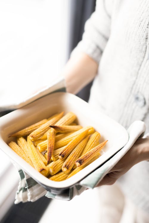 Person Holding White Ceramic Bowl With Yellow Corns