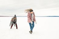 一对穿着温暖衣服的夫妇在雪地里玩耍，享受着冬季户外的乐趣