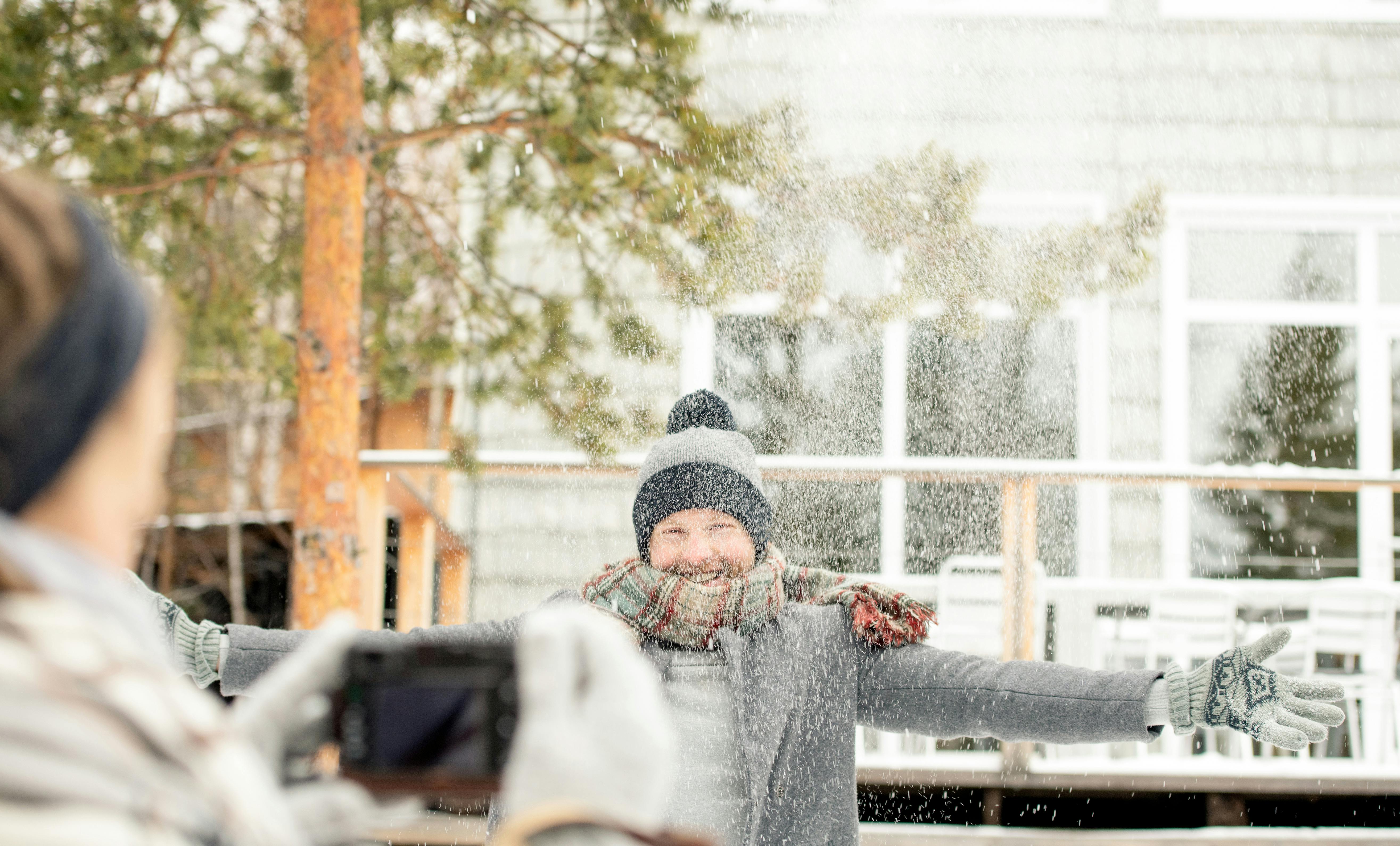男子张开双臂，在雪天里尽情玩耍，捕捉冬日快乐的瞬间