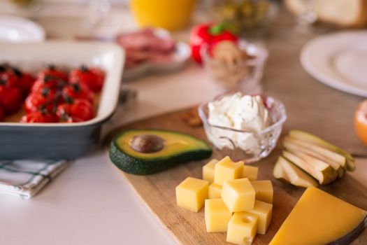 A delectable cheese platter with avocado, tomatoes, and cream cheese, perfect for sharing.