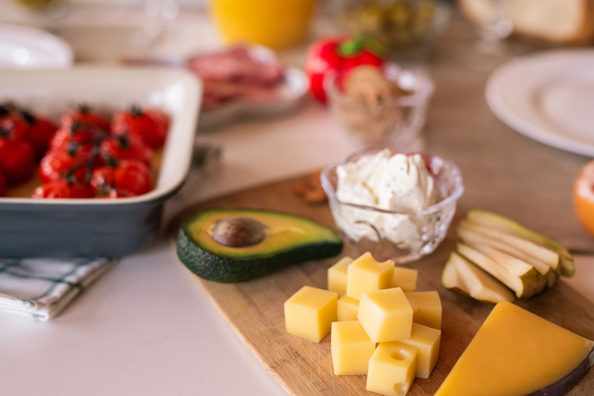 A delectable cheese platter with avocado, tomatoes, and cream cheese, perfect for sharing.