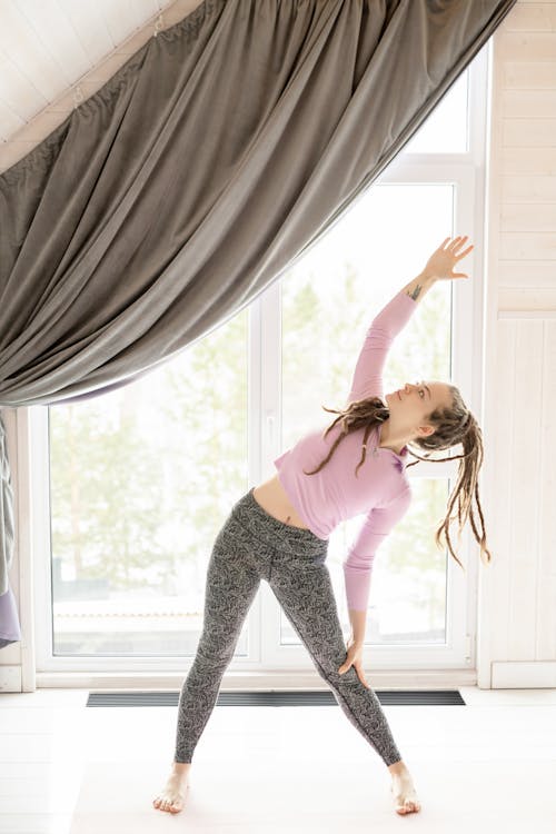 Free Woman In Pink Top And Leggings Stretching Stock Photo