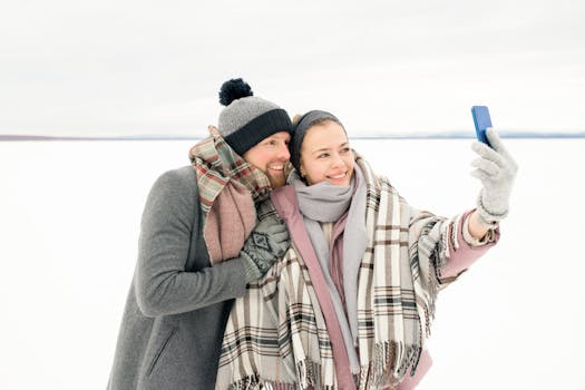 一对穿着冬装的幸福情侣在雪地里自拍，捕捉快乐的瞬间