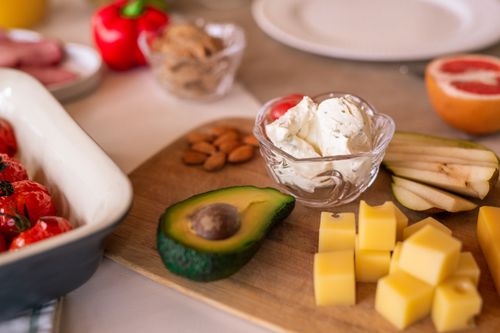 Free A vibrant platter of cheese, fruits, and vegetables on a wooden board, perfect for gatherings. Stock Photo