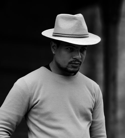 Free Portrait of a young man in a sweater and fedora hat captured in black and white. Stock Photo