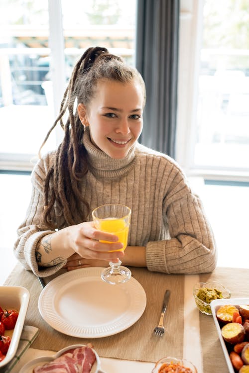 Free Woman In Knit Sweater Holding Clear Drinking Glass Stock Photo