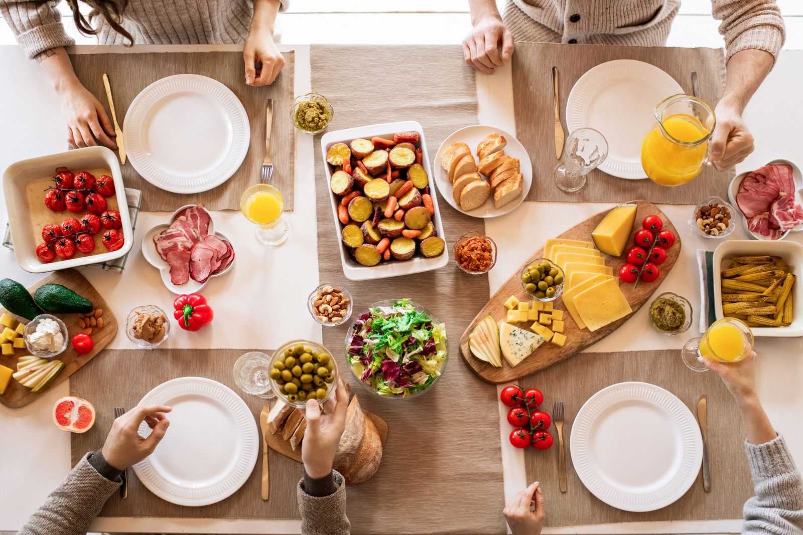 Overhead view of a long table covered with shared dishes — photo by Alexy Almond on Pexels