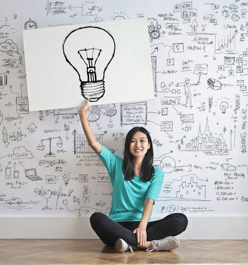 бесплатная Женщина рисует лампочку на белой доске Стоковое фото