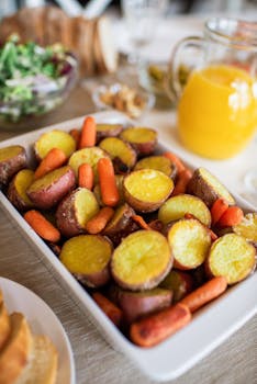 Rustic roasted potatoes and carrots served in a ceramic dish for a hearty meal.
