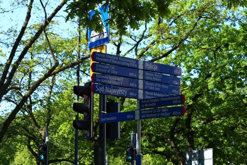 Free A street sign in Warsaw, Poland, showing directions to notable locations. Stock Photo