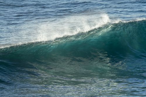 Free Captivating turquoise wave crashing at Culburra Beach, New South Wales, Australia, showcasing the ocean's powerful motion. Stock Photo