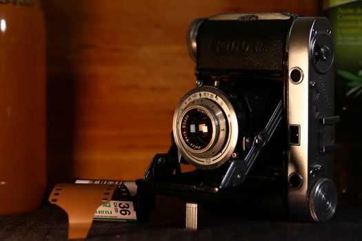 A classic folding camera and a roll of film evoke nostalgia and the art of analog photography.