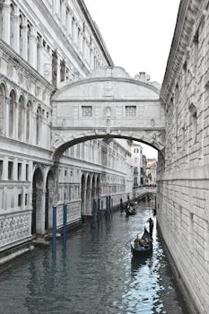 在威尼斯一座历史悠久的桥下，缆车的宁静景色捕捉了永恒的建筑与水道