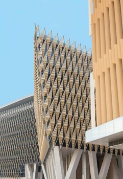 Unique modern building facade featuring intricate lattice patterns under a clear sky.
