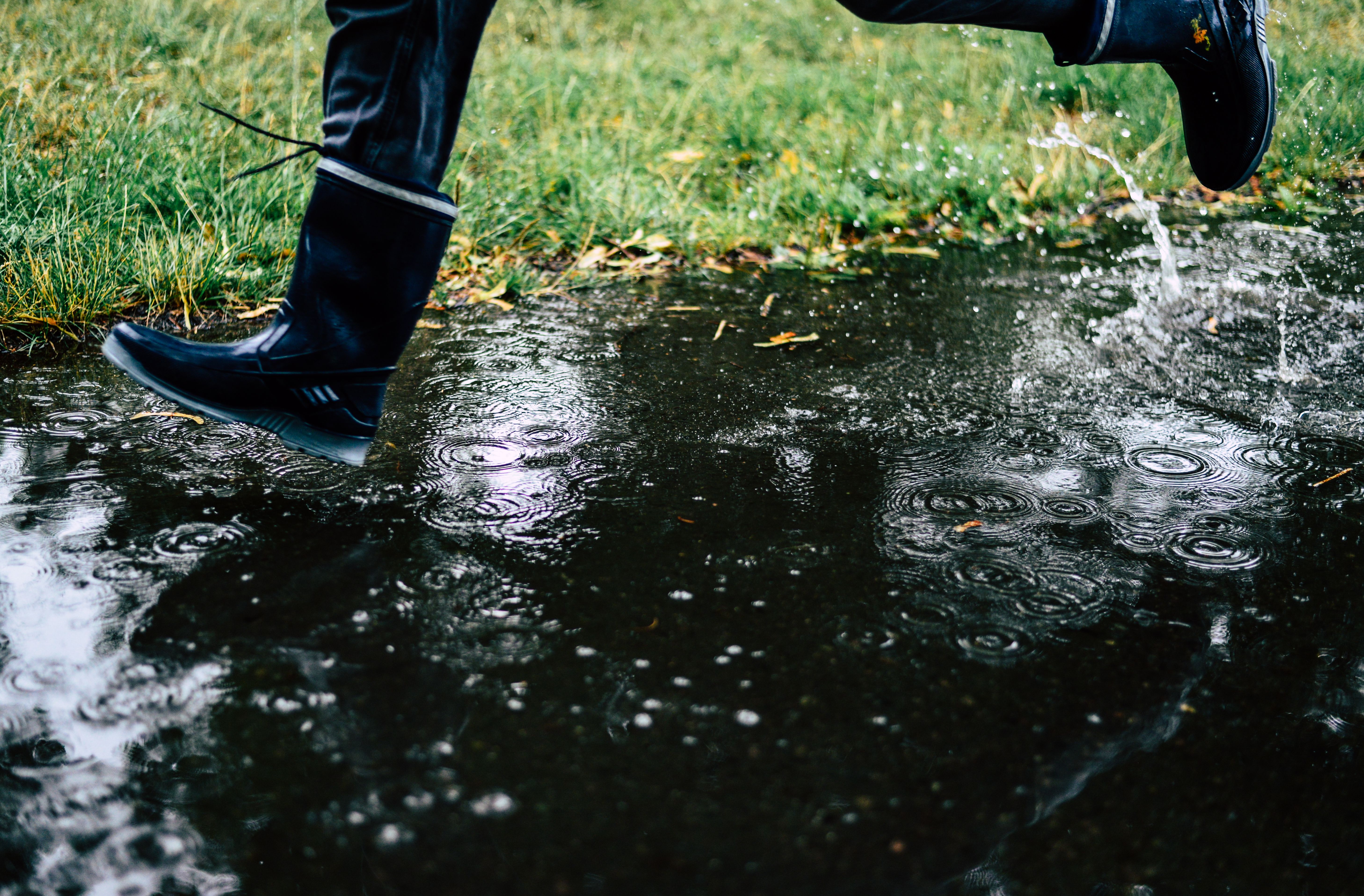 man running with rain boots in the rain