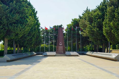Free Memorial site in Azerbaijan with flags and trees creating a serene atmosphere. Stock Photo