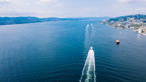 Person in White Shirt Standing on White Ship on Sea