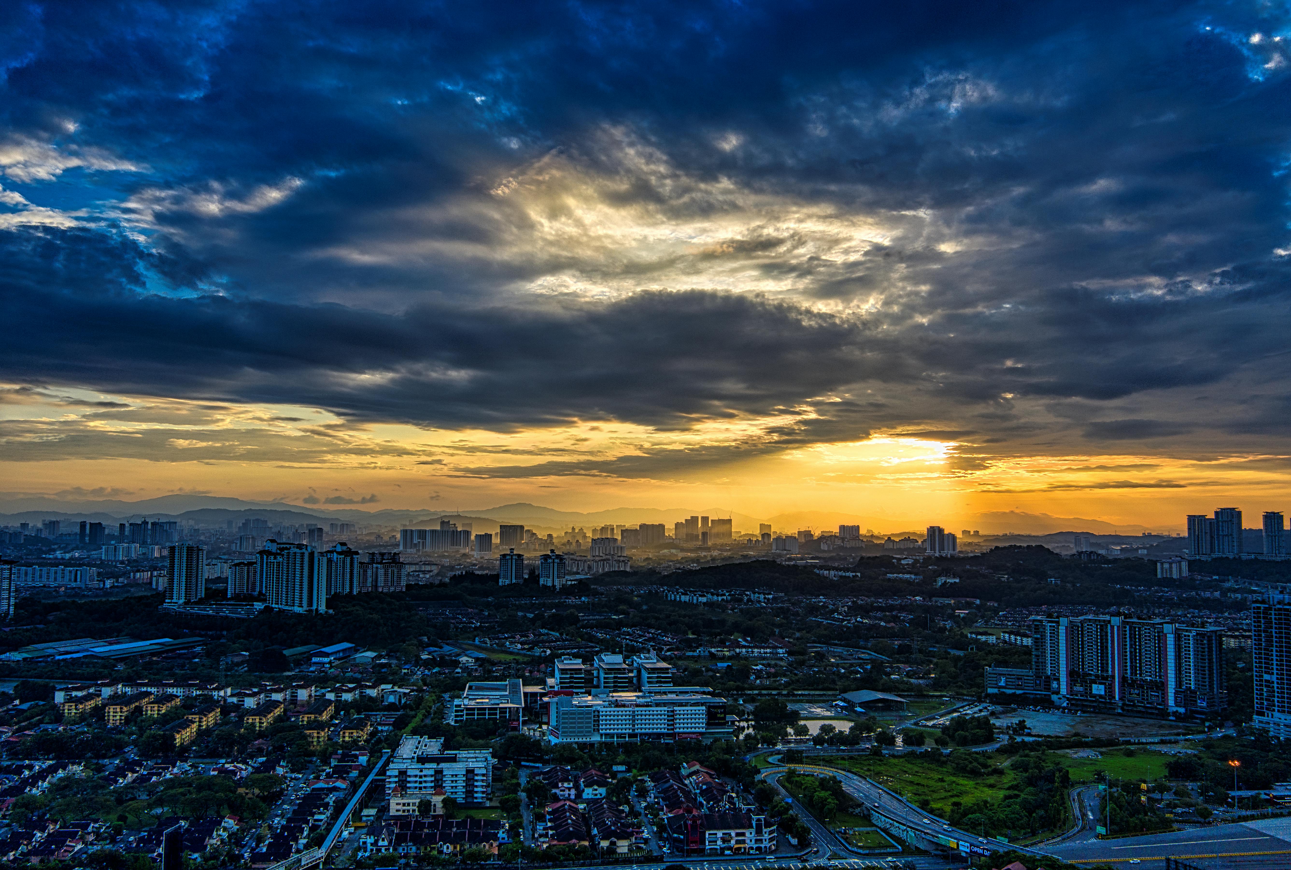 city with high rise buildings under cloudy sky during sunset